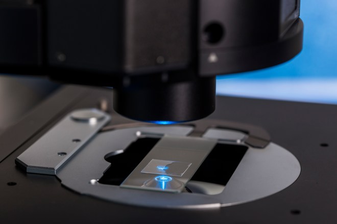 Close-up of a microscope focusing on a glass slide