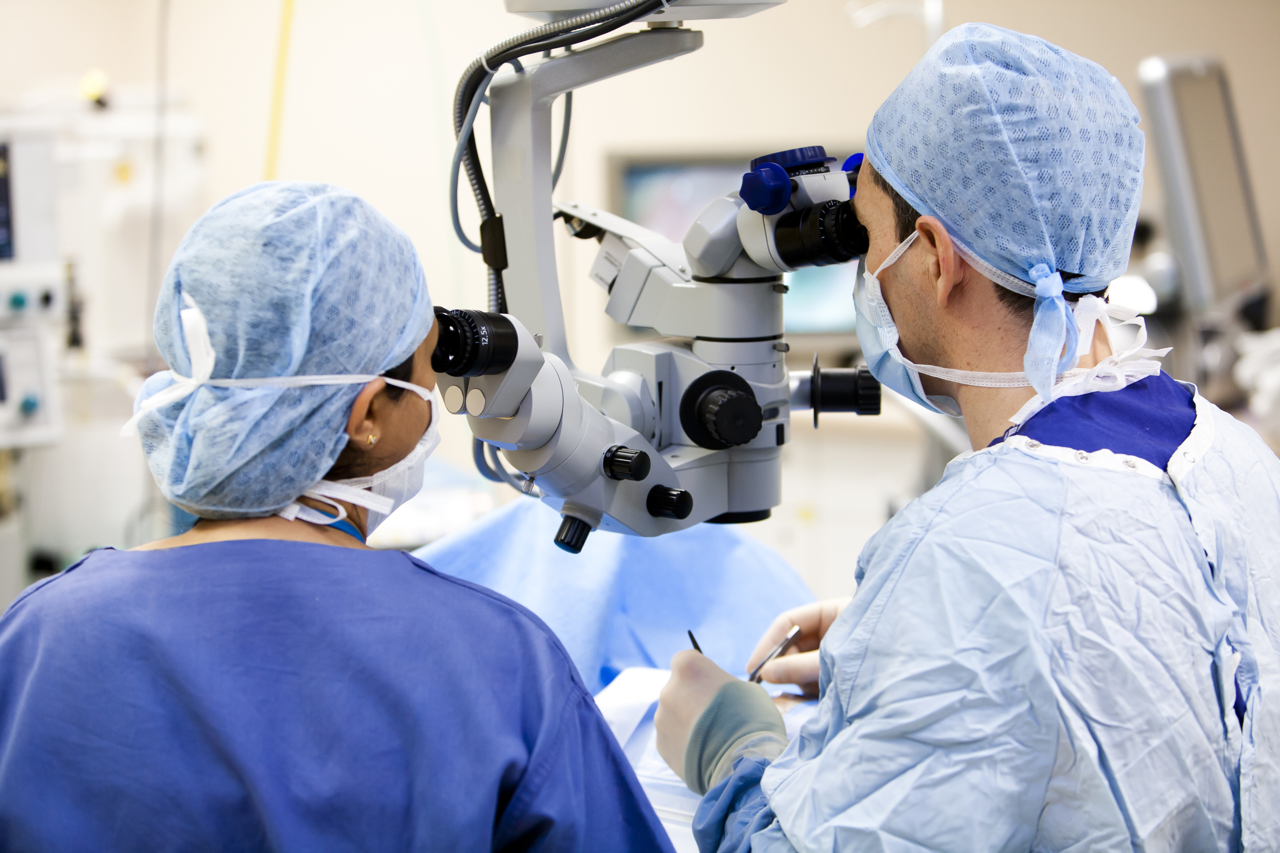 Two ophthalmologists performing cataract surgery in an operating room