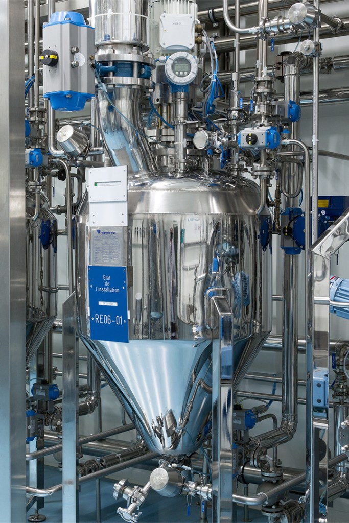 Stainless steel mixing tank with various pipes and gauges
