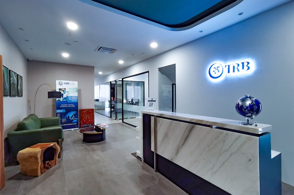 Reception area of TRB office with a green sofa and a globe on the counter.