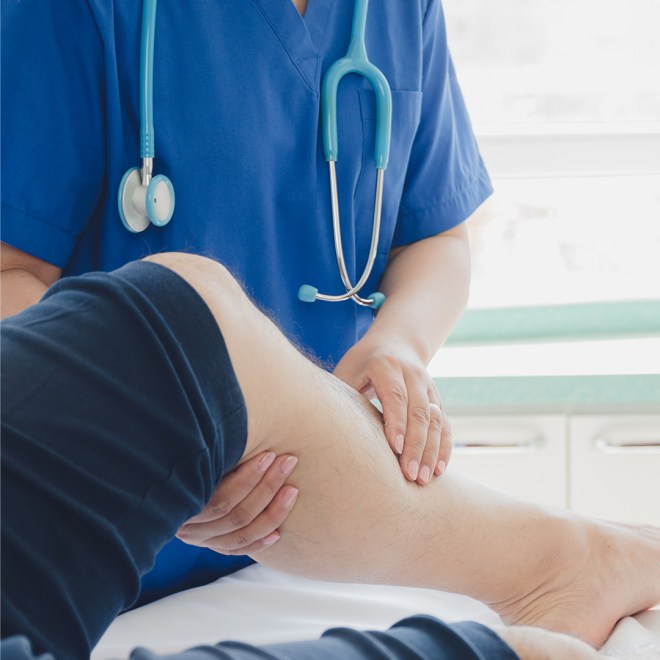 Healthcare professional examining a patient's leg